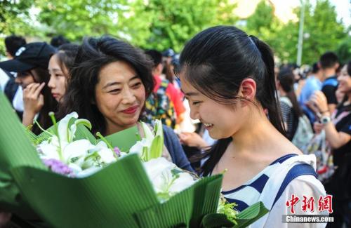 資料圖：山東濟南眾多考生手捧鮮花在家長的簇擁下歡快告別高考。中新社記者 張勇 攝