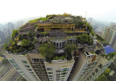 　　昨日，身穿橘黃色馬甲的工作人員在人濟(jì)山莊樓頂拆除違章建筑。新京報(bào)記者 吳江 攝