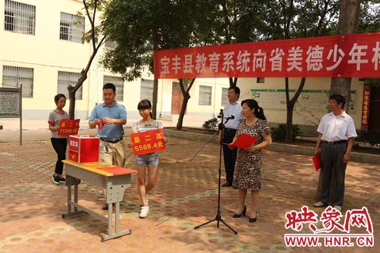寶豐縣教育系統(tǒng)全體人員在石橋鎮(zhèn)中學(xué)為“美德少年”楊冠明同學(xué)捐款。