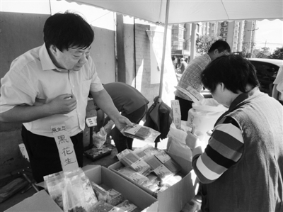 昨日，河南企業(yè)家劉春喜在京“練攤”，為顧客挑選綠豆。新京報記者 張玉學 攝