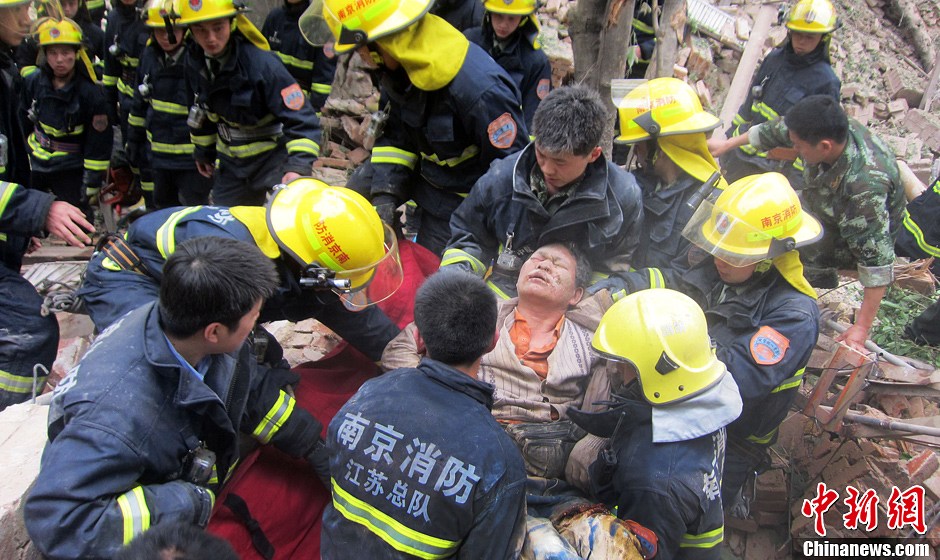圖為南京消防隊員從廢墟中將傷者抬出。中新社發(fā) 梅亮 攝