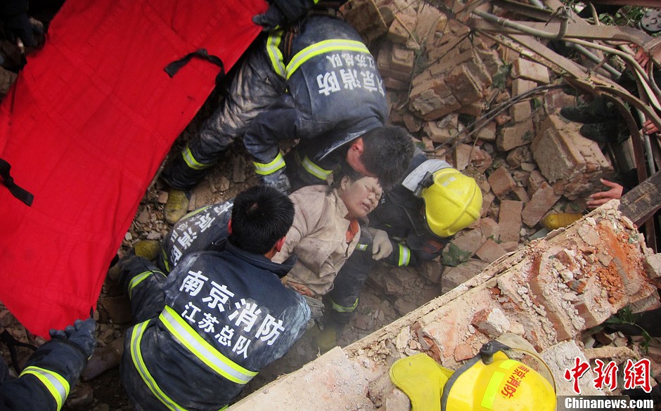 圖為南京消防隊員從廢墟中將傷者抬出。中新社發(fā) 梅亮 攝