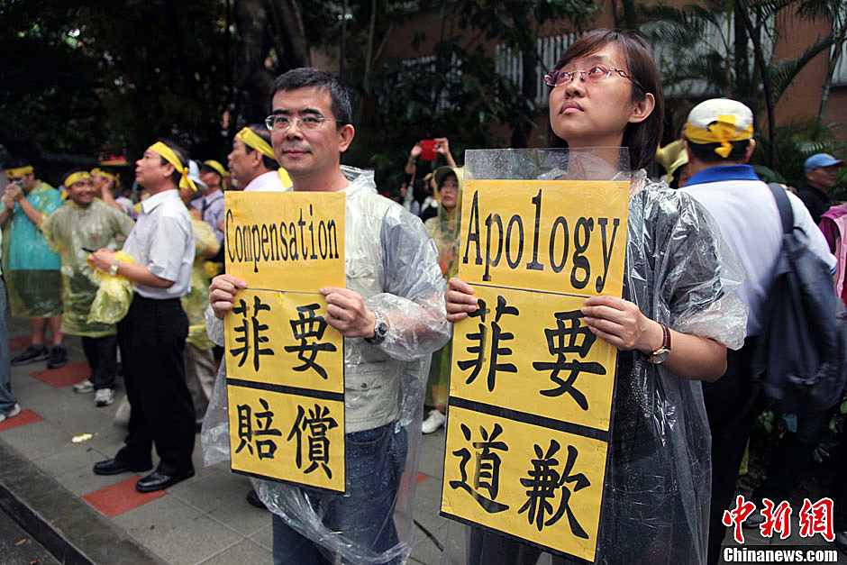 　圖為當(dāng)天下午，當(dāng)臺(tái)灣數(shù)百漁民在馬尼拉經(jīng)濟(jì)文化辦事處前抗議時(shí)，有兩名年輕人手持標(biāo)語，在路邊聲援。中新