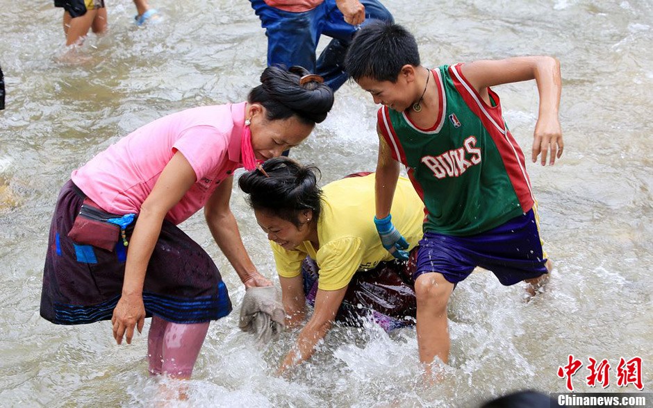 7月9日，村民在小河里摸魚搶魚。譚凱興 攝
