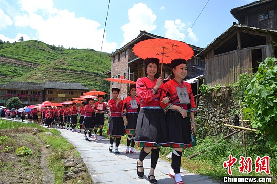 圖為新娘身著瑤族盛裝在伴娘和親友的陪伴下“出嫁”。中新社發(fā) 韋吉陽 攝