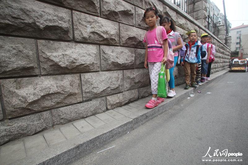 2013年09月11日，濟(jì)南運署街上，小學(xué)生走史上“最窄人行道”上學(xué)。圖片來源：CFP