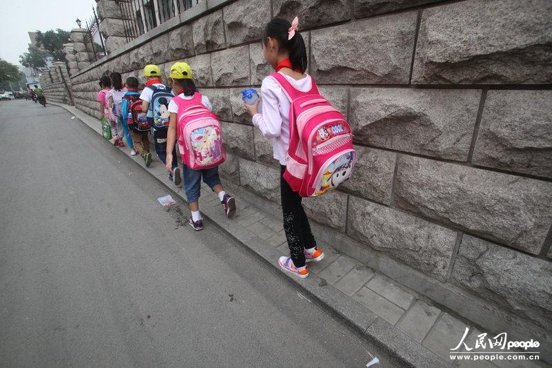 2013年09月11日，濟(jì)南運署街上，小學(xué)生走史上“最窄人行道”上學(xué)。