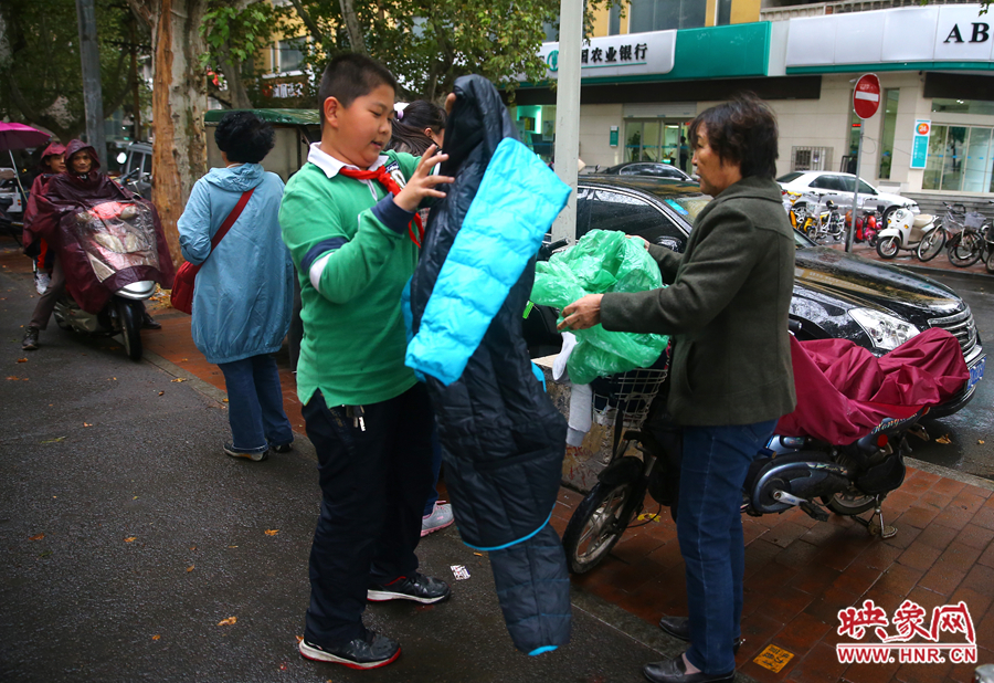 學校門口，家長給孩子帶來了御寒的厚衣服。