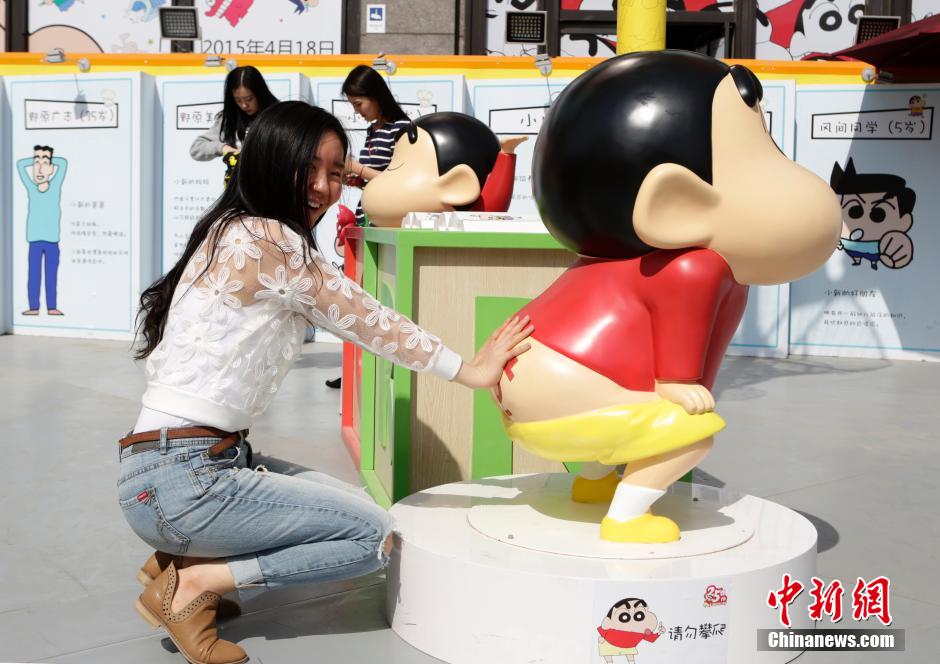 4月22日，游客與蠟筆小新合影?！跋灩P小新25周年紀(jì)念特展”日前在北京開展，吸引了不少市民游客。
