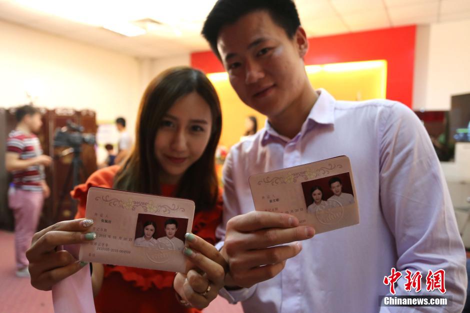 5月20日,河南鄭州,一對準(zhǔn)新人領(lǐng)完結(jié)婚證后秀自拍。