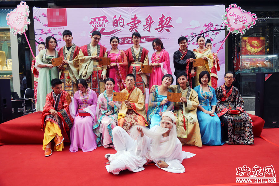現(xiàn)場(chǎng)8對(duì)兒年輕男女舉起“賣(mài)身契”集體拍照。