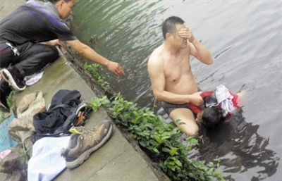 網(wǎng)友貼出民警張光聰一出河水就睜不開眼，用手抹去臉上臟水的照片。