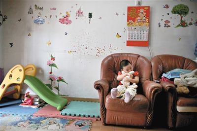 6月14日，未婚媽媽于軍的家里。女兒悅悅抱著兔子玩偶，在聽媽媽手機上的兒歌，這個4歲女孩喜歡兔子。