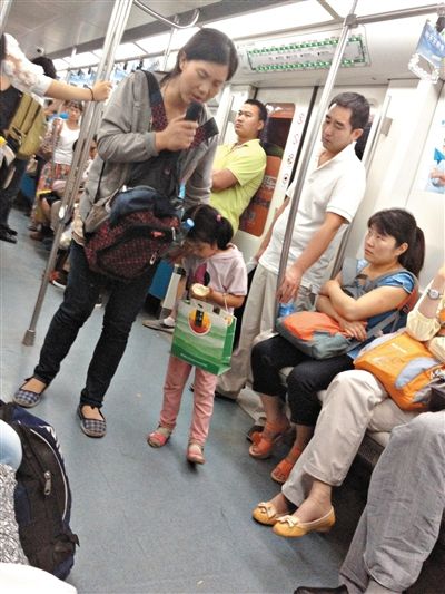 6月27日，舒馨帶一女孩在地鐵十號線行乞。她因被疑帶多個不同小孩乞討被警方搜尋。新京報(bào)記者 申志民 攝