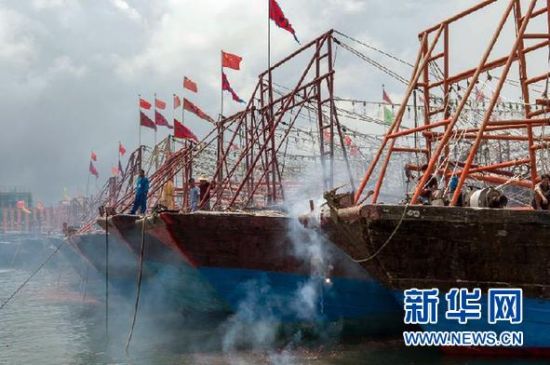 2013年8月1日 南海開漁日 臨高迎新港 8月1日，海南省臨高縣漁民在船上鳴放鞭炮慶祝武蓮港開港。