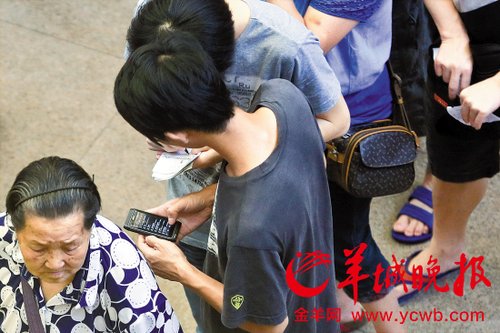 排隊(duì)的“黃?！备魇謭?zhí)一疊白紙，上面寫好了要掛號(hào)的人的信息，包括姓名、電話、要掛的科室等。穿黑白花紋衣服的老婆婆正在排隊(duì)掛號(hào)