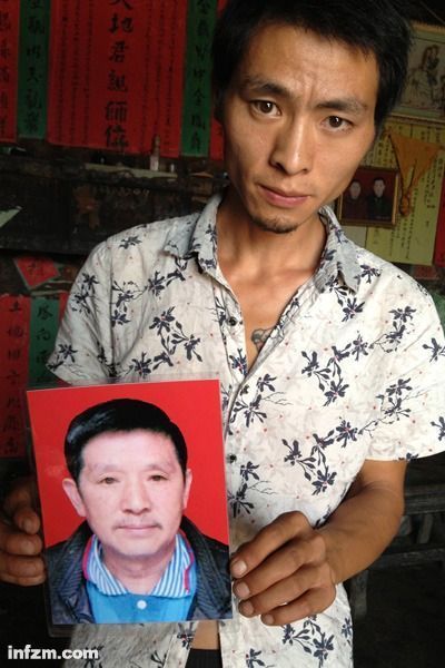 程興貴的兒子程正鵬拿著父親的遺照。程興貴自殺后，政府補償程家6000多塊錢，并終于認(rèn)定了程興貴的代課教齡。 (南方周末記者雷磊/圖)
