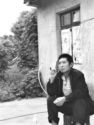 9月12日，陳文才在自己的出租屋旁抽煙。新京報(bào)記者 朱柳笛 攝