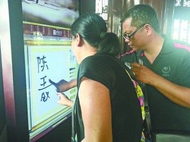 　圖為一對游客夫妻在“涂鴉”。