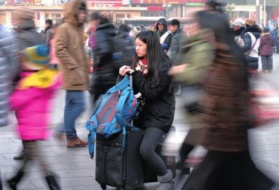 春運(yùn)首日，北京站客流量明顯增多，一名女孩在人流中等待進(jìn)站。