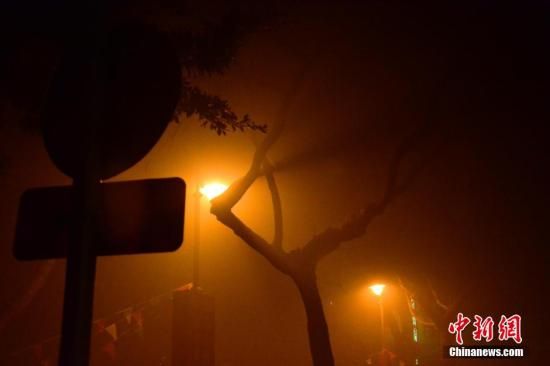 1月31日凌晨，市民行走在煙霧繚繞的南京街頭。當(dāng)天是農(nóng)歷馬年正月初一，南京有限開禁燃放煙花爆竹正逢下霧天，空氣的不流通致使煙花爆竹燃燒后產(chǎn)生的顆粒物不能及時(shí)散開，造成整座城市煙霧繚繞。據(jù)當(dāng)?shù)丨h(huán)保部門發(fā)布的信息顯示，空氣質(zhì)量屬重度污染。中新社發(fā) 泱波 攝