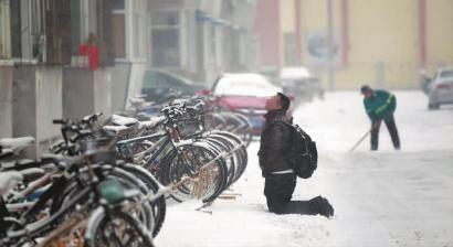 小伙子跪在樓前，一直抬頭看著樓上。 孫立國(guó)/攝