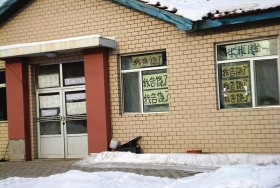 伊春市帶嶺區(qū)一排破舊的平房，房間窗戶上貼滿了“我告饒了”的字樣。