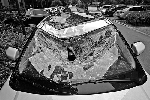 越野車車蓋以及前擋風(fēng)玻璃被砸得凹陷進(jìn)去。見(jiàn)習(xí)記者姚卡/攝