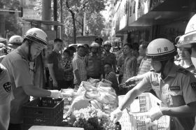 7月11日，瀏陽市北正中路，執(zhí)法人員暫扣張海的水果。這是瀏陽市城管局拍攝的執(zhí)法現(xiàn)場圖。