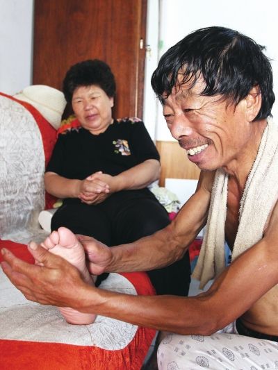 慈成富為老伴按摩。