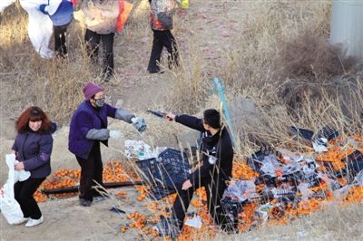 1月4日，連霍高速蘭州市榆中縣和平鎮(zhèn)段，一名警察舉著槍驅(qū)散哄搶橘子的村民。圖/CFP
