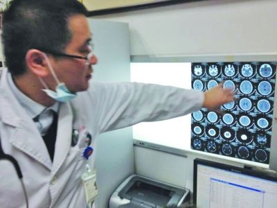 醫(yī)生在查看男孩的腦部CT片。薛馬義 攝