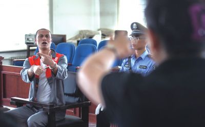 張志國在法庭上用手語回答提問。記者 蒲東峰攝