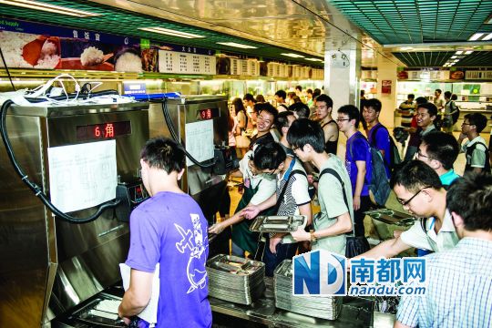 昨日，華南理工大學(xué)一食堂內(nèi)，學(xué)生們正在使用新安裝的自動(dòng)打飯機(jī)打飯。中新社發(fā)