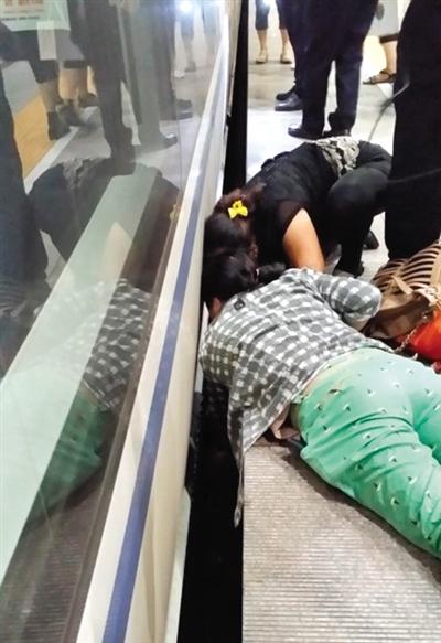 一女子趴在站臺(tái)上，救跌入列車和站臺(tái)間隙的男童。網(wǎng)友璀璨的星月夜 攝