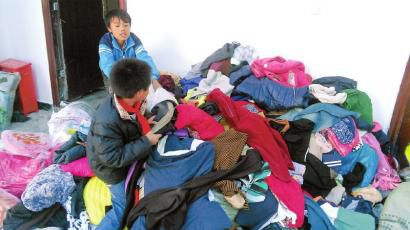 學(xué)生在幫忙整理收到的捐贈(zèng)衣服。得石中心校供圖