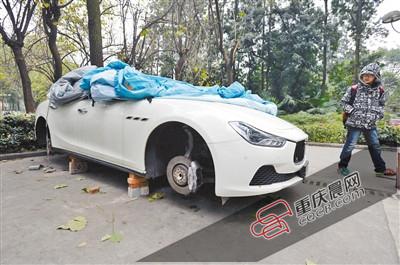 昨日，停放在重慶大學(xué)B區(qū)的一輛瑪莎拉蒂豪車被架在幾塊磚頭上，車輪不翼而飛。 重慶晨報(bào)記者 胡杰 攝