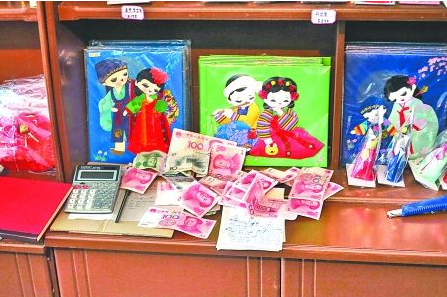 　　2012年6月21日，在朝鮮羅先特別市的一家商店里，柜臺(tái)上散落著一些人民幣。在朝鮮，人民幣比本國(guó)