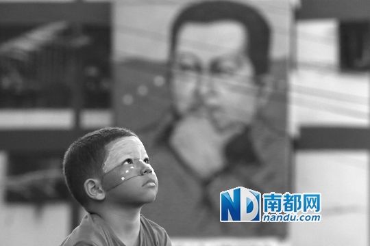 3月5日，一名委內(nèi)瑞拉兒童仰望天空，他身后是查韋斯的陵墓。