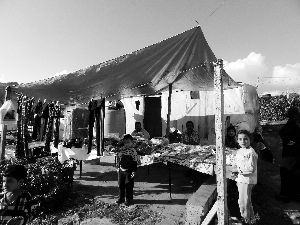 黎巴嫩一敘利亞難民營(yíng)，難民支起攤鋪賣衣服掙錢。