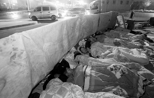 在寒冷的冬夜，為了能省點錢，方便接活，民工們仍睡在橋下。