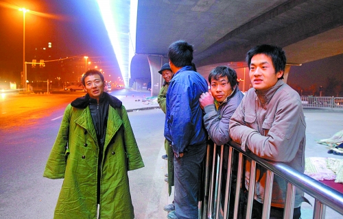 冬夜里，農(nóng)民工在橋下等著干活兒。