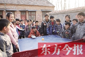 坐著輪椅的小宗成和同學(xué)們一塊打乒乓球，這是他感到最快樂(lè)的事