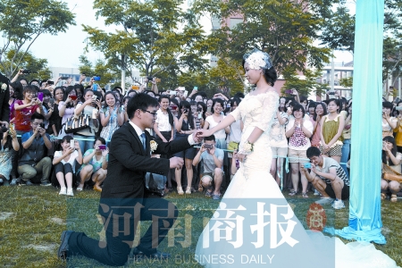 在學(xué)校操場(chǎng)的草坪上，兩名畢業(yè)生舉行婚禮，有同學(xué)感動(dòng)地抹起眼淚
