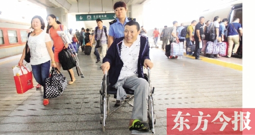 李剛手術(shù)后歸來(lái)，在車(chē)站工作人員幫助下走出鄭州火車(chē)站站臺(tái)  東方今報(bào)首席記者 張曉冬 攝