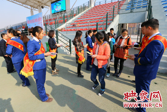 活動(dòng)現(xiàn)場(chǎng)工作人員給同學(xué)們發(fā)放宣傳冊(cè)、環(huán)保袋。