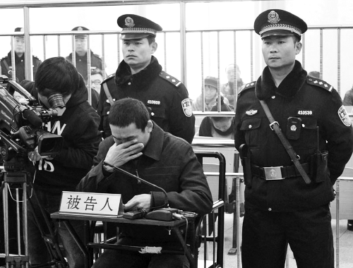 庭審中,29歲的李軍低著頭。
