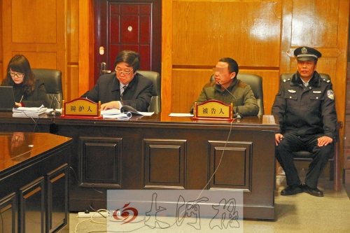 庭審現(xiàn)場，被告人坐在律師身旁為自己辯護。