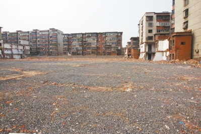 為降塵，旮旯王村拆遷后裸露的地面上鋪了一層石子。