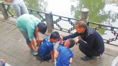 男孩被救出后，圍觀群眾幫他控水換衣服。